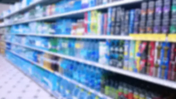 Abstract blur image of supermarket background. Defocused shelves with products. Grocery store. Retail industry. Rack. Discount. Inflation concept. Aisle. Consumer packaged goods. CPG. Shopping.