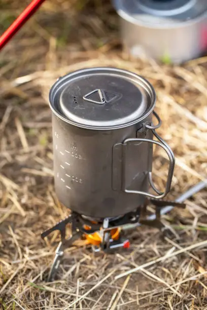 Touristic titanium mug on the gas-burner outdoors