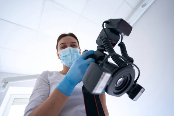 istock Joyous dentist holding digital camera in her hands 1414856533