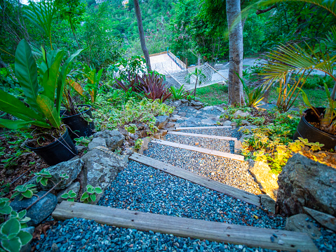Steep gravel stairs leading down to a hammock in the jungle