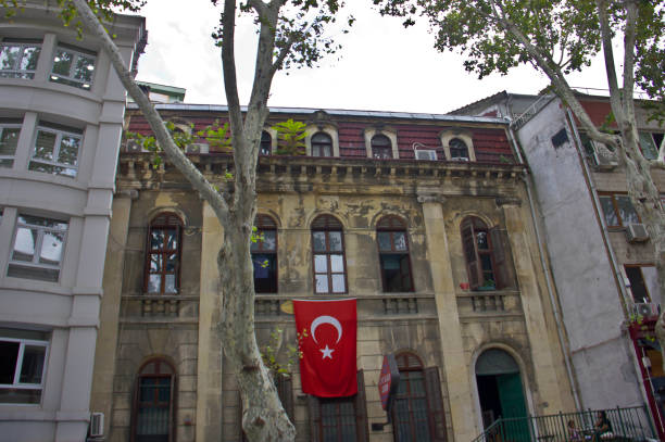 Istanbul,Turkey - August 10, 2022: An old apartment from late 1800's in Nuru Osmaniye Mosque near grand bazaar kapalı çarşı in Istanbul. Photo from beyazıt, fatih province. People walk and shop in fatih beyazıt, there are famous for jewelery, spice, leather and Turkish carpet shopping.