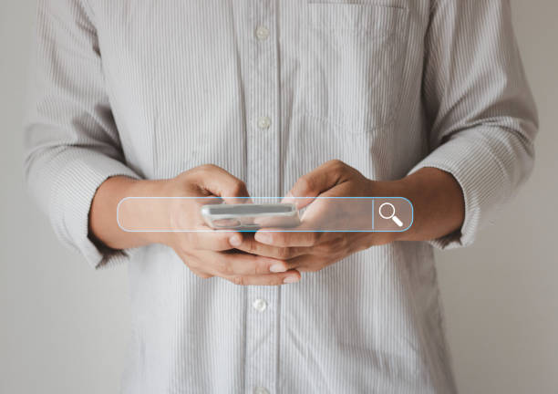 istock Business People hand using mobile phone or smartphone searching for information in internet online society web with search box icon. 1414859584