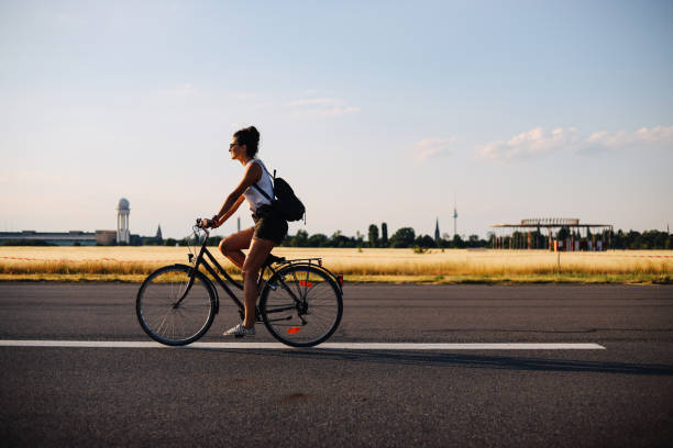 ベルリンのテンペルホーフで自転車に乗っている女性 - tempelhof ストックフォトと画像