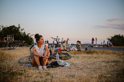 Commuter woman or a tourist enjoying a beautiful day is riding her bicycle through Tempelhof, a large open space area of a former airport.