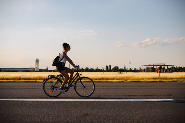 kobieta jadąca na rowerze w tempelhof, berlin - tempelhof zdjęcia i obrazy z banku zdjęć