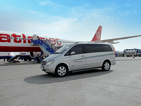 Antalya, Turkey - May 27, 2007: VIP shuttle service van on airport platform waiting beside a jumbo jet.