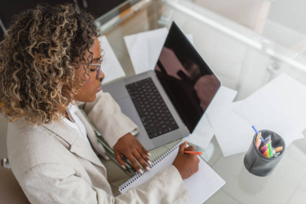 istock woman writing at work in the office 1414863089