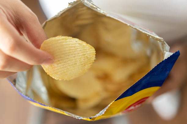 Hand hold potato chips with snack bag stock photo