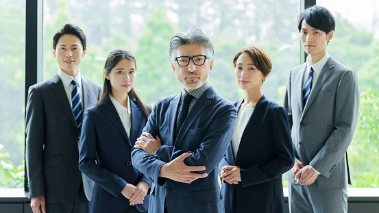 portrait of group of asian businessperson standing by the window