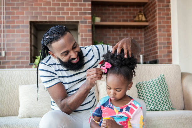 padre che pettina la figlia dei capelli - padre single foto e immagini stock