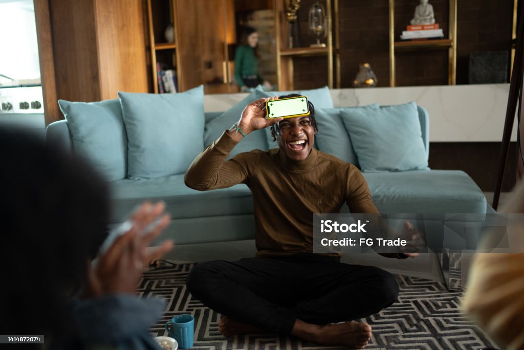Friends playing guessing game at home Playing Stock Photo