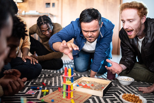 Special needs boy playing board game with friends at home