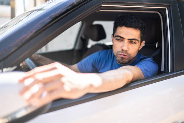 istock Man in a car arranging rearview mirror 1414874855