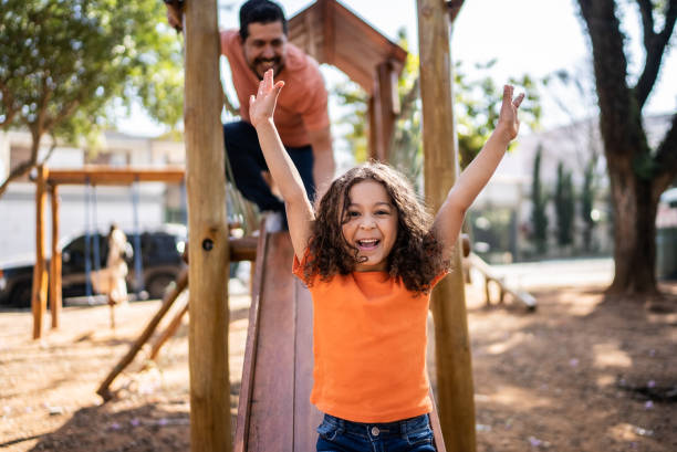 istock Happy girl sliding down in a playground 1414874894