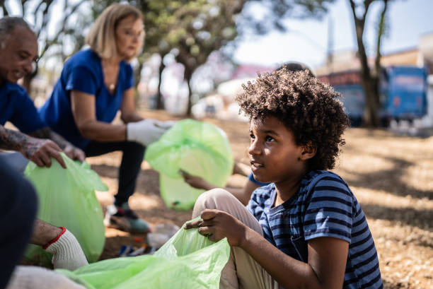 istock Boy pickung up garbage to clean a public park 1414875780