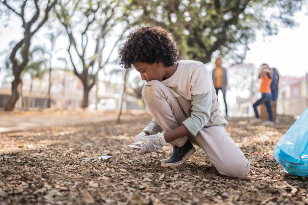 istock Boy picking up garbage to clean a public park 1414875938