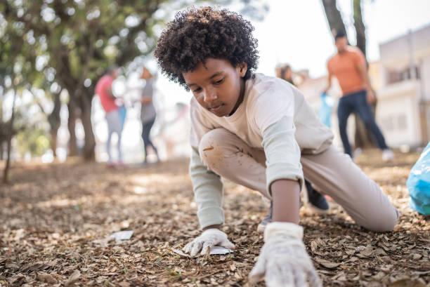 istock Boy picking up garbage to clean a public park 1414875958