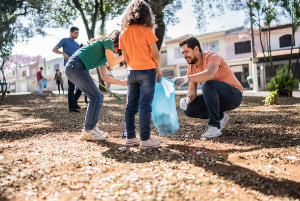 istock Father and daughters picking up garbage at a public park 1414876209