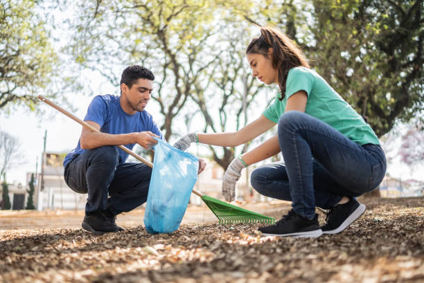 istock Couple picking up garbage to clean a public park 1414876222