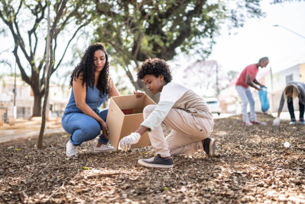 Mother and son picking up garbage to clean a public park