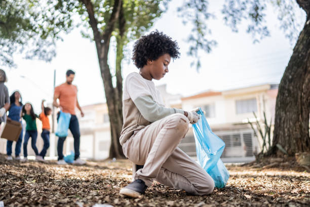 istock Boy picking up garbage to clean a public park 1414876243