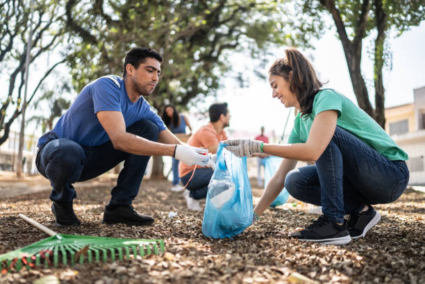 istock Couple picking up garbage to clean a public park 1414876278