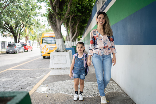 Mother and schoolgirl daughter walking to school or home