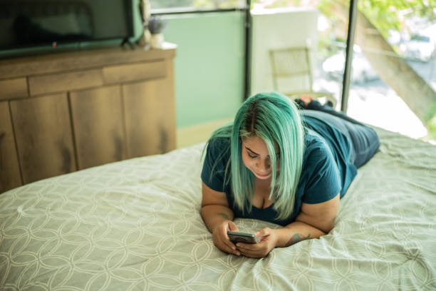 istock Mid adult woman using phone at home 1414877523