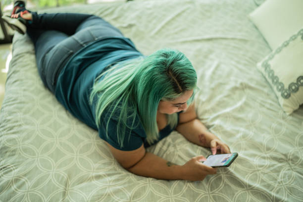 istock Mid adult woman using phone at home 1414877526
