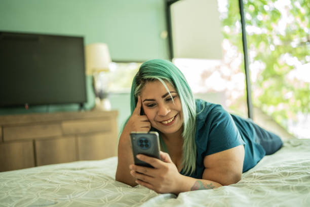 istock Mid adult woman doing a video call using mobile phone at home 1414877534
