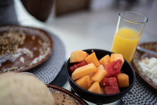 Bowl of fresh fruit and orange juice