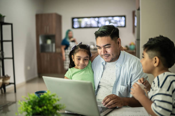 istock Father with his kids using laptop watching something or working at home 1414877793