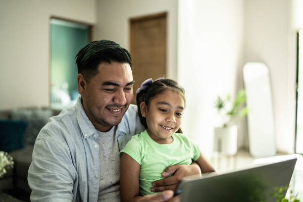 istock Father and daughter using laptop at home 1414877819