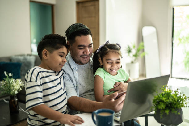 padre con sus hijos usando la computadora portátil y el teléfono móvil viendo algo en casa - latinoamericano fotografías e imágenes de stock