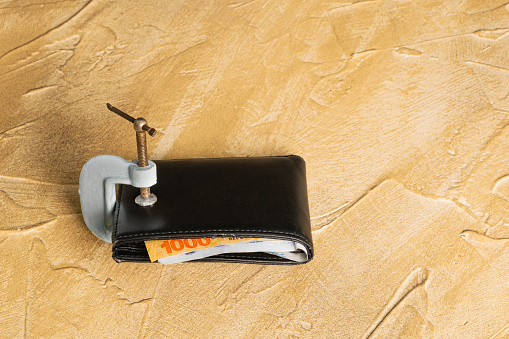 Wallet with argentine pesos sticking out closed with a c clamp
