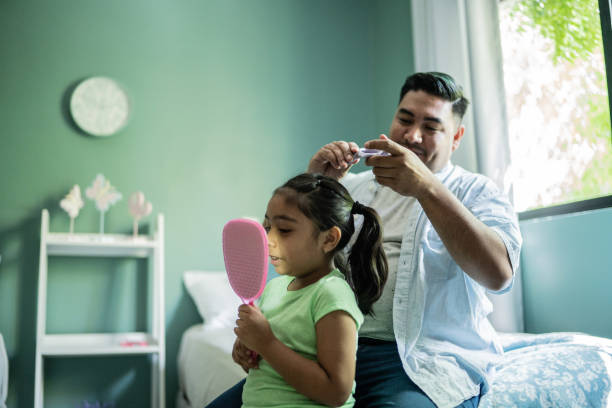 istock Father combing daughter's hair at home 1414877887