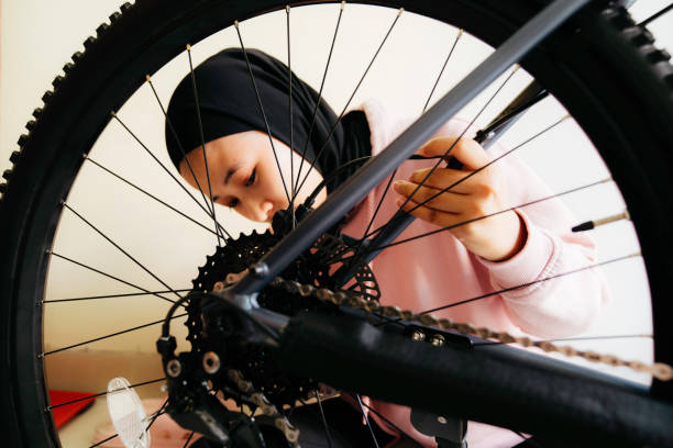 istock muslim woman  fixing bicycle on sunny day 1414878688