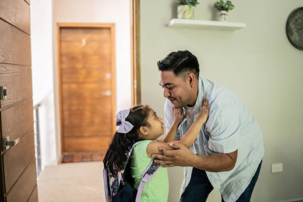 istock Father helping his daughter at home before school 1414878795