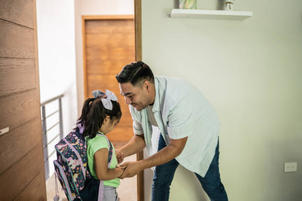 istock Father helping his daughter at home before school 1414878810