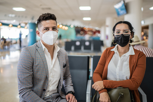 Portrait of coworkers using protective mask in the departure area at airport