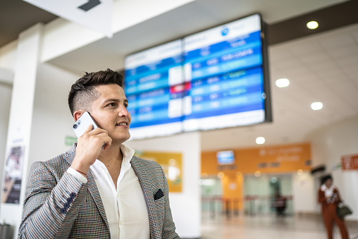 Business man talking on smartphone at the airport