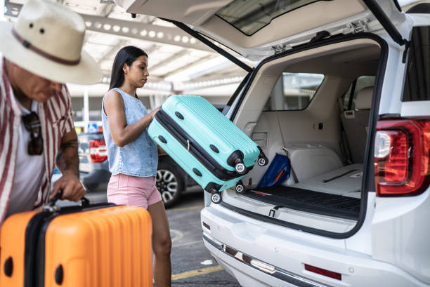 istock Couple putting suitcases in car trunk 1414881079
