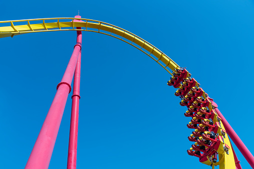 Rollercoaster railroad  track high to the sky roll bend and twist exciting machine fun people at theme park.