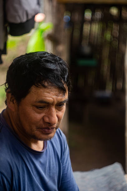 istock Latino man working on separating green coffee cherries from ripe ones 1414893696