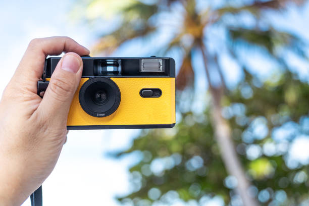 istock Travel preparations. Man holding a film camera on a vacation 1414895538