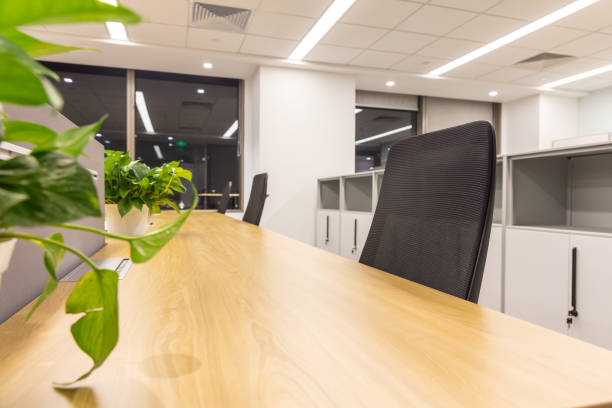istock Empty modern office interior with tables and armchairs, some plants 1414898596