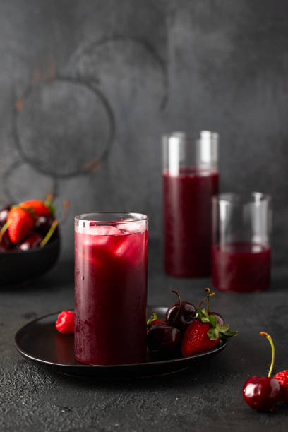 istock Fresh berries juce made with different berries cherry, strawberry and raspberry on dark background. 1414899642