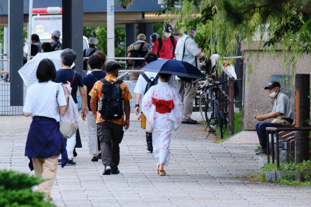 Young woman in summer kimono among tourists in Kyoto stock photo