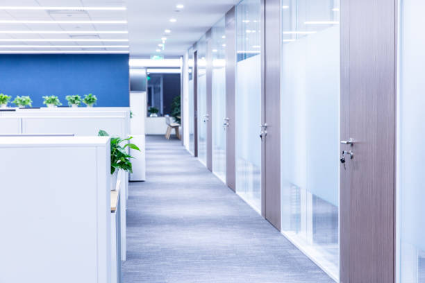 istock Open office interior with long corridor and wooden door with key in it 1414902219