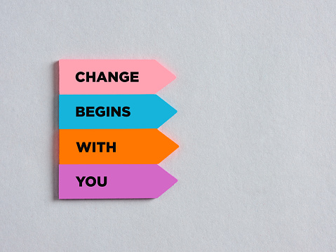 Colorful arrow shaped stickers with the message change begins with you. Business career or lifestyle motivational message.